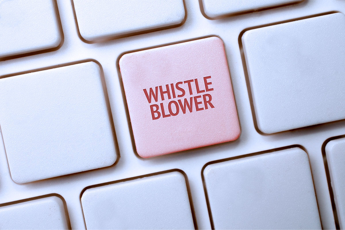 Abbildung einer weißen Tastatur mit einer rot gefärbten Taste mit Schriftzug "Whistleblower"
